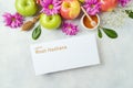 Jewish holiday Rosh Hashanah greeting card mock up. Top view background with apples, flowers and honey. Flat lay Royalty Free Stock Photo