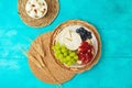 Jewish holiday Shavuot festive table setting with cheese, fruits and wheat ears on wooden blue table background. Top view from