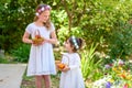 Jewish Holiday Shavuot.Harvest.Two little girls in white dress holds a basket with fresh fruit in a summer garden. Royalty Free Stock Photo