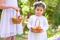 Jewish Holiday Shavuot.Harvest.Two little girls in white dress holds a basket with fresh fruit in a summer garden. Royalty Free Stock Photo