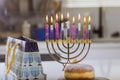 The Jewish holiday symbol the Chanukah burning candles to the Hanukkiah Menorah on a blurred background represents the