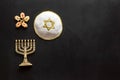 Jewish Kippah Yarmulkes hats with menorah on black wooden table. Top view, copy space