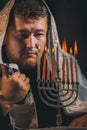 Jewish man with beard lighting the candles in prayer of a menorah lights candles Hanukkah Royalty Free Stock Photo