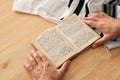 Jewish man hands holding a Prayer book, praying, next to tallit. Jewish traditional symbols. Rosh hashanah jewish New Year holida Royalty Free Stock Photo