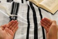 Jewish man hands next to Prayer book, praying, next to tallit. Jewish traditional symbols. Rosh hashanah jewish New Year holiday Royalty Free Stock Photo