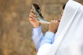 Jewish man in tallit blowing shofar. Rosh Hashanah celebration