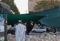 A Jewish man wrapped in a tallit prays outside the synagogue on Sukkot