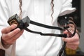 Jewish Man wrapped in tefillin pray . A religious orthodox with arm-tefillin on his left hand prays