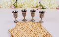 Jewish matzah bread on white background with four wine cups. Passover holiday concept