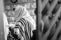 Jewish men praying in a synagogue with Tallit