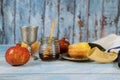 Jewish New Year symbols with shofar glass honey jar, fresh apples, and pomegranates celebrating Rosh Hashanah