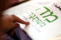 Jewish person reading from the Haggadah on Passover Seder Meal