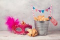 Jewish Purim holiday concept with hamantaschen cookies or hamans ears in bucket and carnival mask Royalty Free Stock Photo