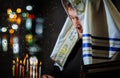 Jewish Religion holiday symbol for male hand lighting candles in menorah on table Hanukkah