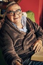 Jewish senior with glasses in the armchair reading a torah book