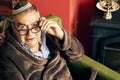 Jewish senior with glasses in the armchair