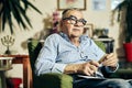 Pensive Jewish senior in the armchair reading a torah book