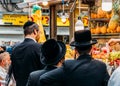 Jewish ultra-orthodox people inspect pineapples at Jerusalem`s Shruk Machane Yehuda market, which has over 250 food stalls offeri