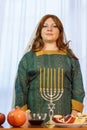 A Jewish woman with her head covered stands at the festive table in honor of Rosh Hashanah. Royalty Free Stock Photo