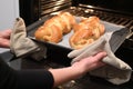 Jewish woman taking out baked Challah Bread out of the oven