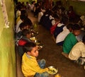 Mid day meal program, an Indian government initiative, is being running in a primary school. Pupils are taking their meal