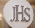 THe JHS sign during the First Holy Communion Reception