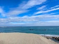 Jian Stream leading to the Pacific Ocean via a beach with tetrapods and people enjoying the beach under a sunny blue sky Royalty Free Stock Photo