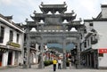 Jiangwan in Wuyuan County, Jiangxi Province, China. Wide street with ornate stone gate and people.
