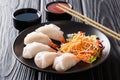 jiaozi, gyoza dumplings with prawns close-up served with vegetable and soy and tomato sauces. horizontal