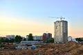 Jib construction tower crane and new residential buildings at a construction site on the sunset and blue sky background Royalty Free Stock Photo