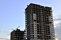 Jib construction tower crane and new residential buildings at a construction site on the sunset and blue sky background Royalty Free Stock Photo