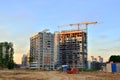 Jib construction tower crane and new residential buildings at a construction site on the sunset and blue sky background Royalty Free Stock Photo