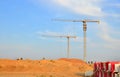 Jib construction tower cranes at a construction site on the blue sky background Royalty Free Stock Photo