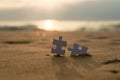 Jigsaw on the beach sand matching puzzle pieces together Royalty Free Stock Photo