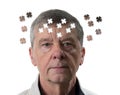 Jigsaw concept of mental illness or dementia with senior caucasian man looking sad into camera