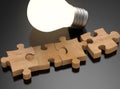 Jigsaw pieces with shining light bulb Royalty Free Stock Photo