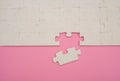 Jigsaw puzzle with one piece loose on pink