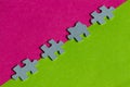 Jigsaw Puzzle pieces on border between pink and green background Royalty Free Stock Photo