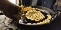 Jilapi or Jilebi making on a big pan.Street food jilapi making in deep hot oil on a big pan
