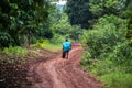 African kid is playing with a wheel in the forest. Jinja, Uganda.