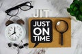 JIT - Just In Time acronym with alarm clock and magnifying glass, business concept background Royalty Free Stock Photo