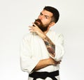 Jiu Jitsu master with black belt rubs his beard.