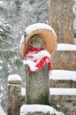 Jizo or stone statue wearing red apron under snow