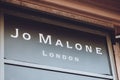 Jo Malone London brend sign on city street. Signboard logo of Jo Malone London, British perfume and scented candle brand shop,