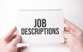 Job Descriptions word inscription on white card paper sheet in hands of a man. Black letters on white paper. Business concept Royalty Free Stock Photo