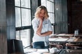 Job almost done. Businesswoman with curly blonde hair indoors in cafe at daytime