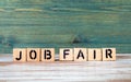 Job Fair. Text from alphabet blocks on a green and white wooden background