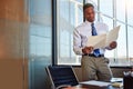 Less a job, more a calling. a young male lawyer standing by his desk in the office.