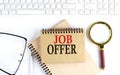 JOB OFFER text in the office notebook with keyboard, magnifier and glasses , business concept Royalty Free Stock Photo