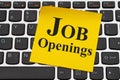 Job Openings message on yellow sticky note on a keyboard